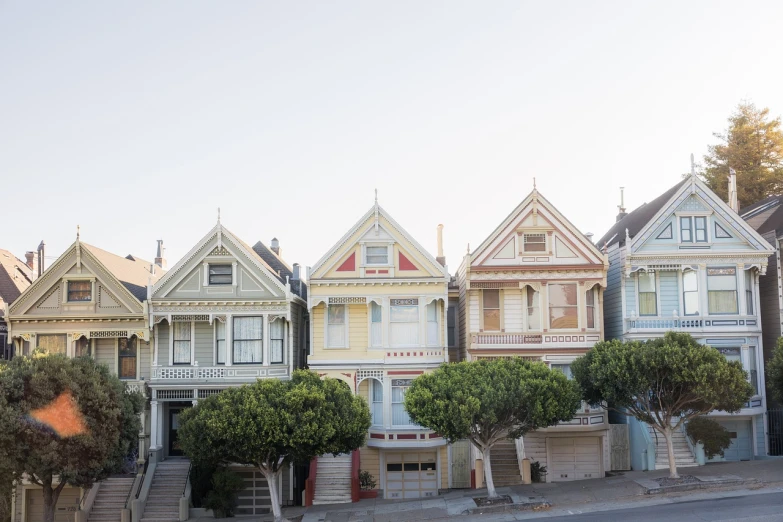 a row of houses sitting on the side of a road, inspired by Wes Anderson, shutterstock, art nouveau, san francisco, shot on leica sl2, 7 0 s photo