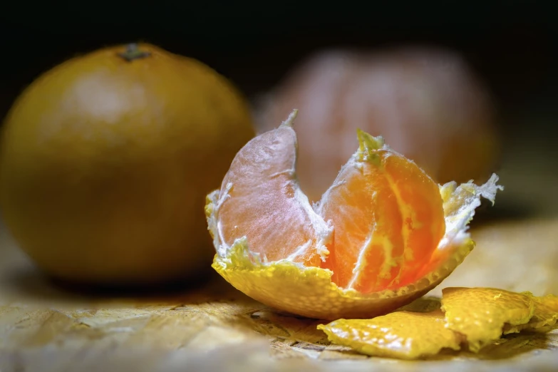 a peeled orange sitting on top of a wooden table, a macro photograph, cinematic morning light, various posed, fruits, close-up product photo