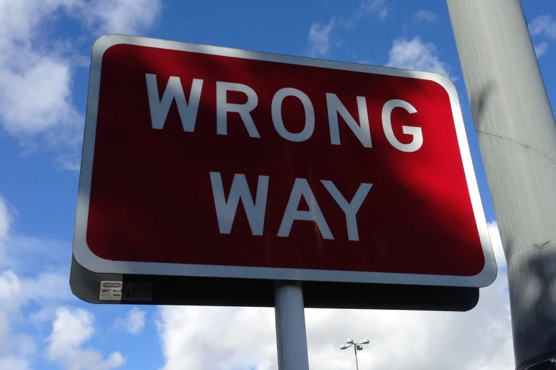 a red wrong way sign on a pole, by James Warhola, discovered photo, error, c 4 d ”, alex jones