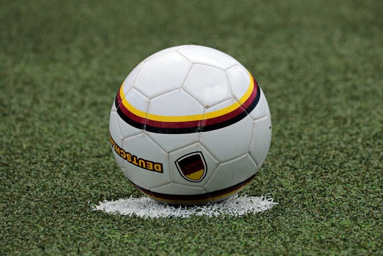 a soccer ball sitting on top of a soccer field, inspired by Hermann Rüdisühli, granular detail, train with maroon, high quality product image”