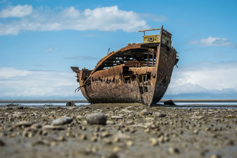 a rusty boat sitting on top of a sandy beach, a portrait, by Alexander Robertson, pixabay, giant sentinel crashed on earth, side profile shot, water surrounds the ship, afar