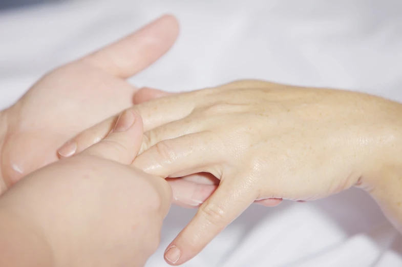 a close up of a person holding a baby's hand, a stock photo, shutterstock, figuration libre, acupuncture treatment, with pointing finger, high res photo