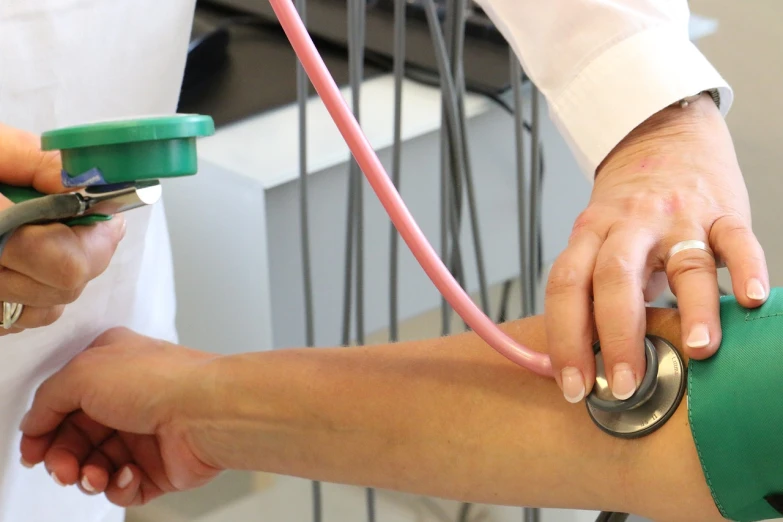 a doctor using a stethoscope on a patient's leg, a picture, button potenciometers, press shot, coloured, elbow