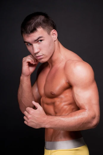 a man in yellow trunks posing for a picture, a portrait, by Aleksander Gierymski, shutterstock, very beautiful. big muscles, 18 years old, square masculine jaw, vladimir pchelin