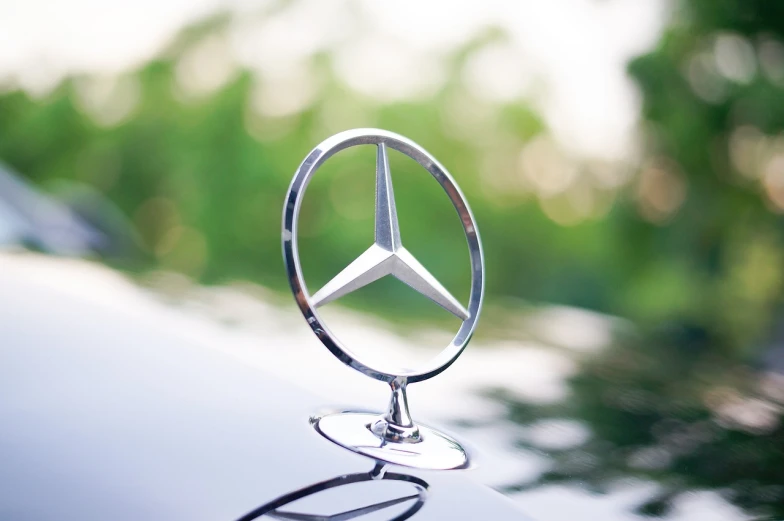 a mercedes logo on the hood of a car, by Thomas Bock, shutterstock, on a pedestal, shot in canon 50mm f/1.2, celebration, discovered photo