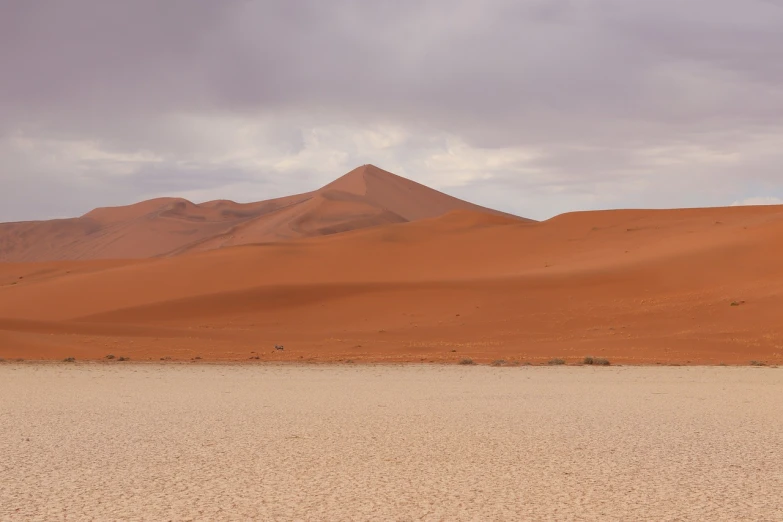 a person riding a horse in the middle of a desert, a picture, by Arie Smit, shutterstock, color field, big overcast, dune, 3 / 4 extra - wide shot, red!! sand