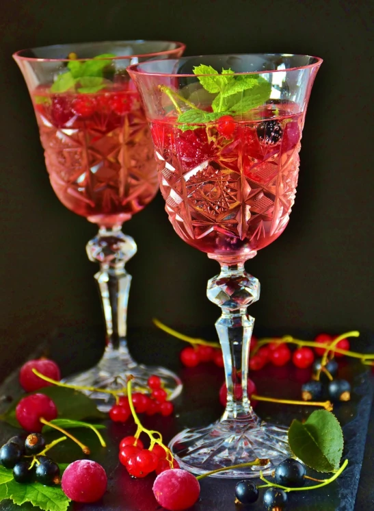 a couple of wine glasses sitting on top of a table, by Zofia Stryjenska, romanticism, berry juice, high quality product image”