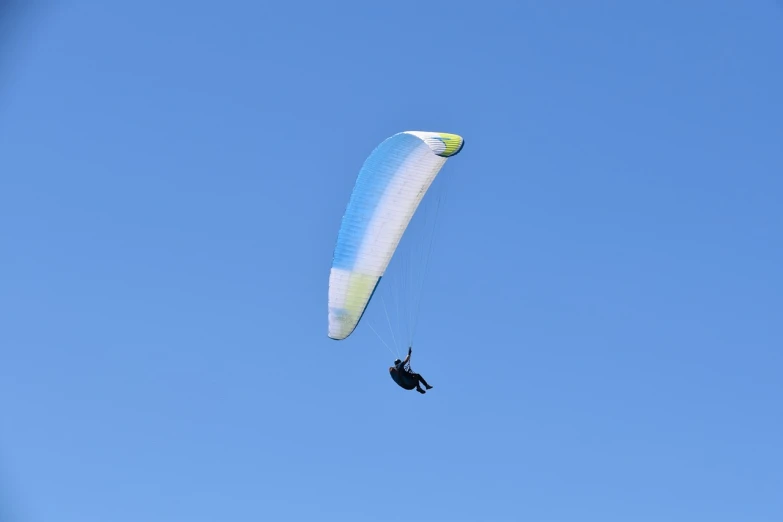 a person that is in the air with a parachute, a picture, by Julian Allen, shutterstock, clear blue sky, ornithopter, pale blue backlight, profile view