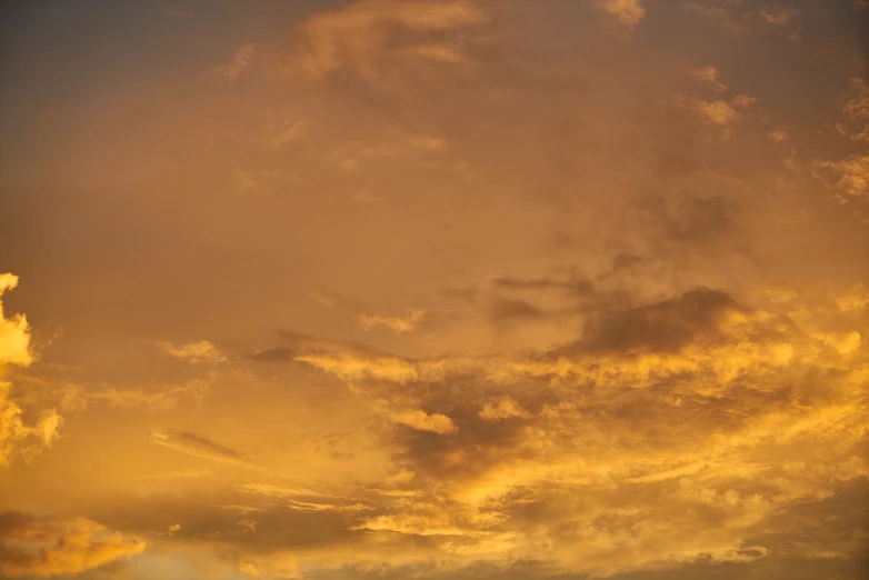 a large jetliner flying through a cloudy sky, a picture, romanticism, shades of gold display naturally, sunset photo, gradient yellow, ceremonial clouds