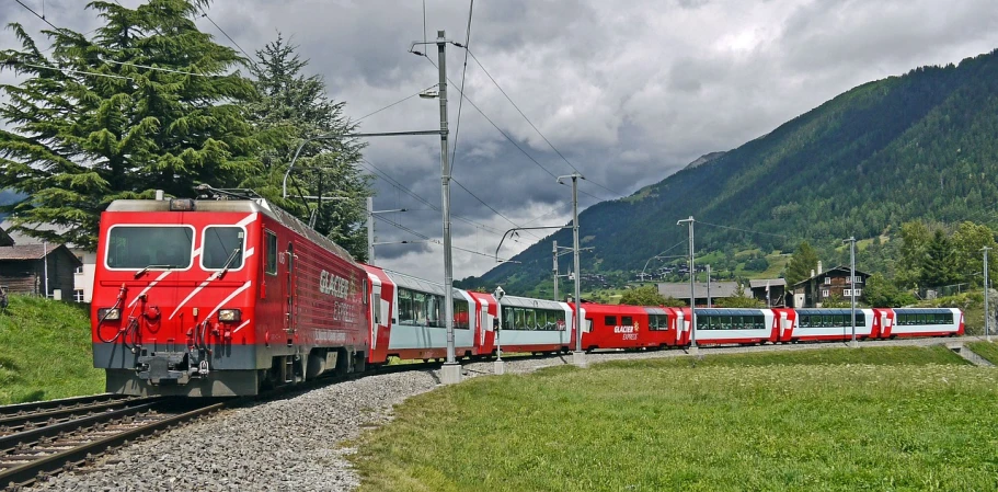 a red and white train traveling down train tracks, by Hans Schwarz, flickr, buses, made of swiss cheese wheels, panoramic, goat