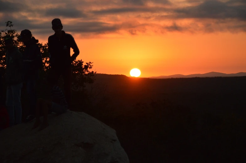 a couple of people standing on top of a rock, a picture, by Alexander Runciman, sunset in the distance, william penn state forest, bushveld background, header