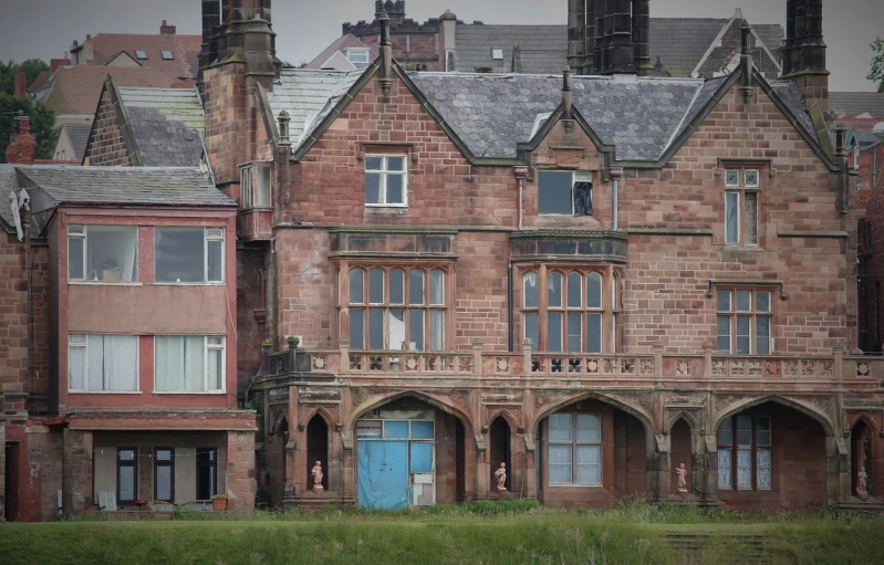 a large brick building with a blue door, by Richard Carline, pixabay, art nouveau, viewed from the ocean, derelict house, pink marble building, house bolton