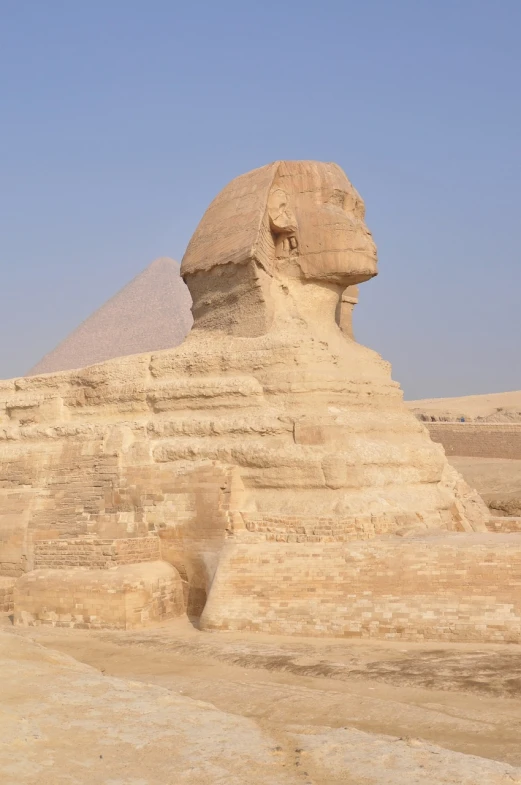 a statue of a sphinx in front of a pyramid, egyptian art, by Joseph Henderson, shutterstock, side view from afar, above side view, built in the egyptian desert, stone statue