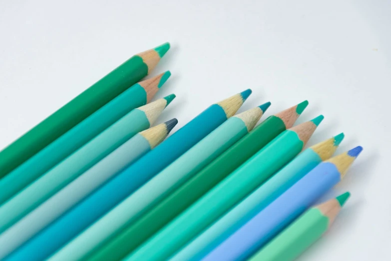 a group of colored pencils sitting next to each other, a color pencil sketch, by Richard Carline, floating. greenish blue, close-up product photo, high quality product photo, view from bottom to top