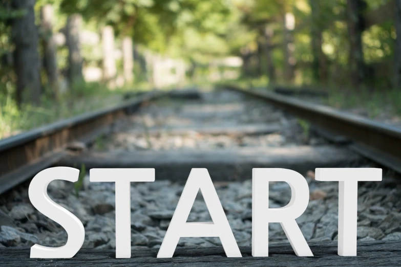 a train track with the word start written on it, a picture, happening, website banner, looking straight into the camera, ground-breaking, starts