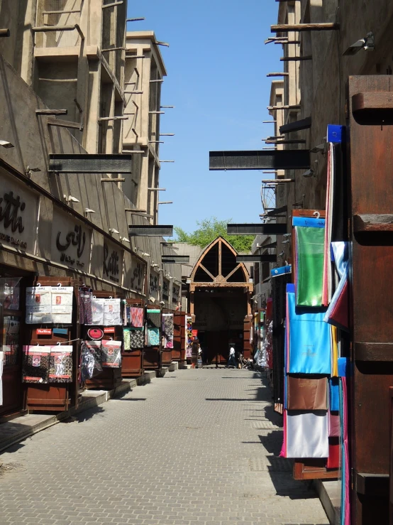 a street filled with lots of shops next to tall buildings, hurufiyya, wooden structures, ameera al taweel, archways between stalagtites, image