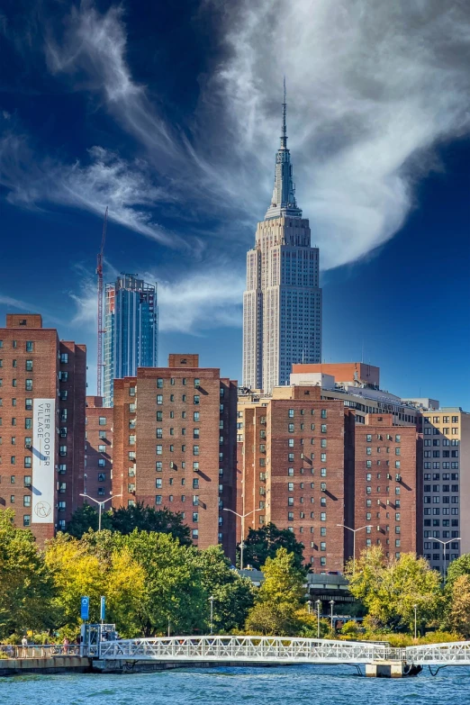 a body of water with buildings in the background, by William Woodward, unsplash, modernism, empire state building, harlem, wide angle shot 4 k hdr, all buildings on bridge