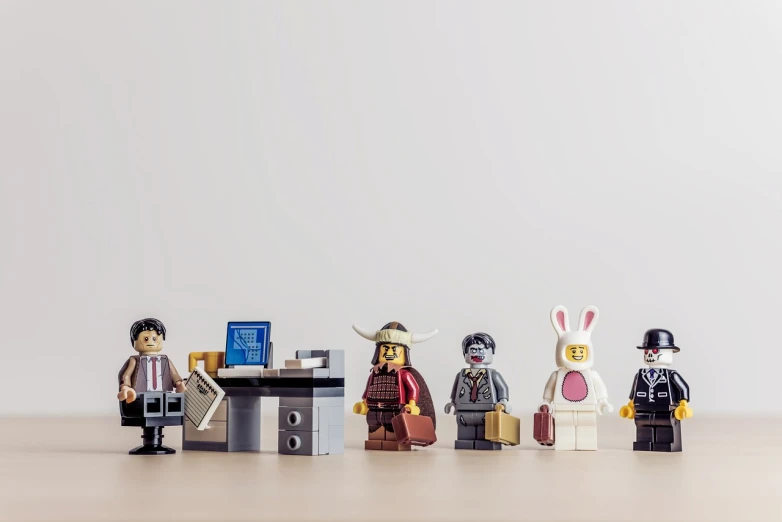 a group of legos sitting on top of a wooden table, a picture, by Romain brook, pexels contest winner, pixel art, bunny suit, office cubicles, long cinematic shot, lined up horizontally