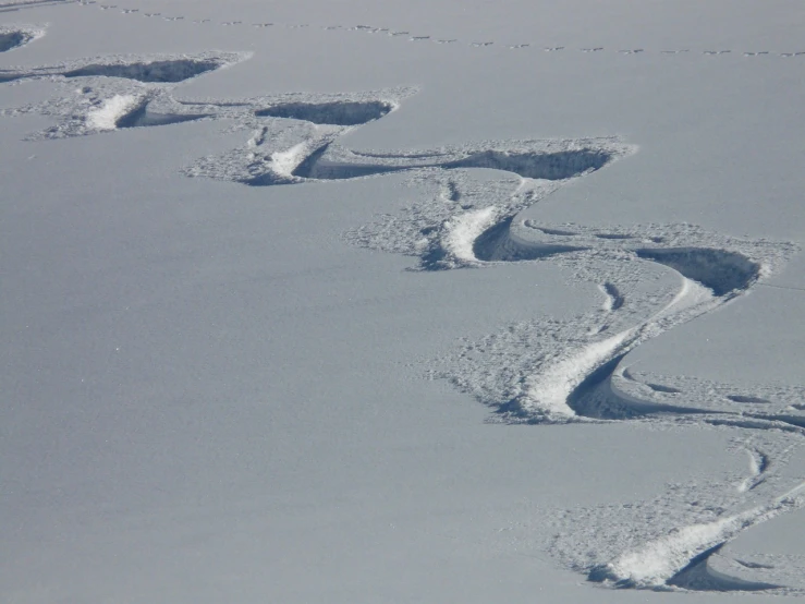 a person riding skis down a snow covered slope, flickr, figuration libre, swirly lunar ripples, in a row, antarctica, crazy detail