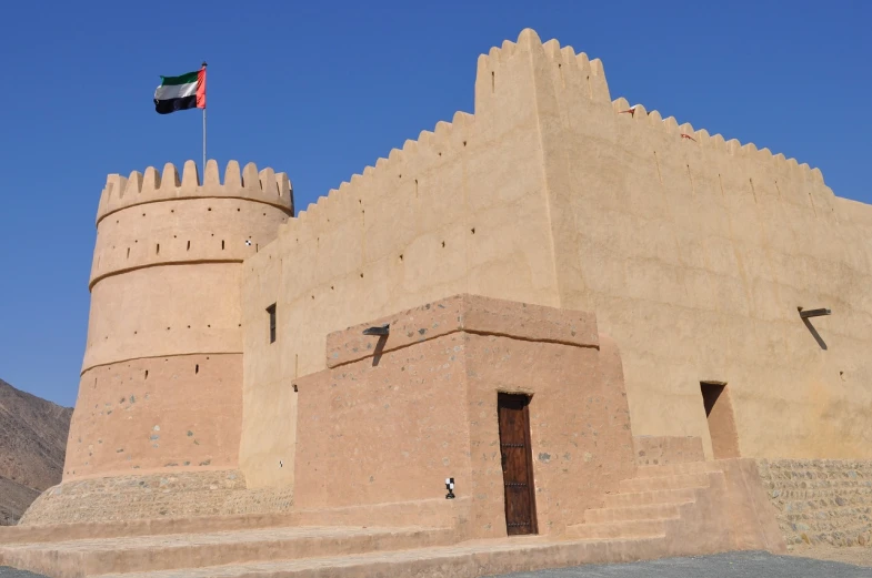 a building with a flag on top of it, dau-al-set, fortresses, tanned ameera al taweel, museum photo, sunny day time