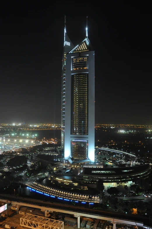 an aerial view of a city at night, hurufiyya, colossal tower, exterior, zenith view, flawless structure
