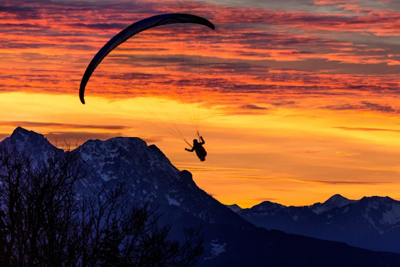 a person that is in the air with a parachute, a picture, by Cedric Peyravernay, shutterstock, mountains and colorful sunset!!, backlit!!, colorado, gliding