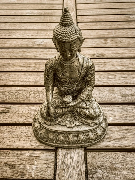 a statue sitting on top of a wooden floor, by Richard Carline, pexels, cloisonnism, orton effect intricate, deck, buddhist, detailed scan”