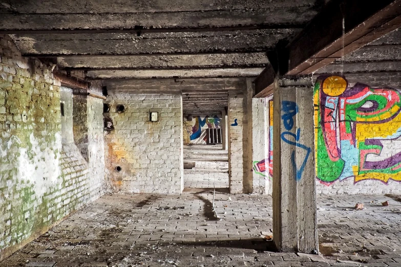 an empty room with graffiti on the walls, by Thomas Häfner, graffiti, old lumber mill remains, underground city, concrete pillars, colorfull painting
