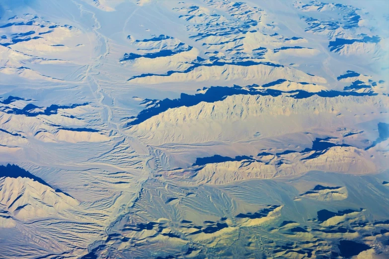 a view of a mountain range from an airplane, flickr, hurufiyya, erosion channels river, ice mountains afar, on a remote desert planet, crisp contour lines