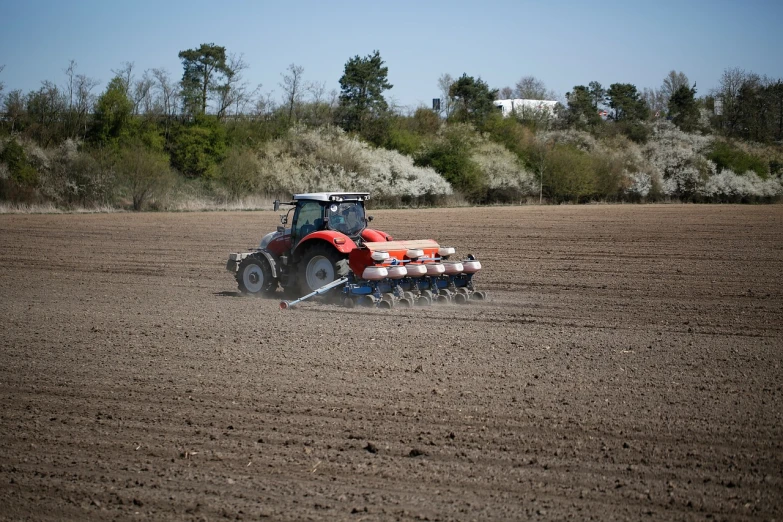 a tractor plowing a field with a seeder, a photo, by Niels Lergaard, figuration libre, b - roll, andrzej marszalek, ground breaking, panel