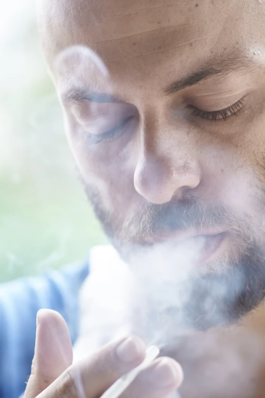 a close up of a person smoking a cigarette, a picture, by Jakob Gauermann, shutterstock, mist rising from head, 30 year old man, nebulizer equipment, istockphoto