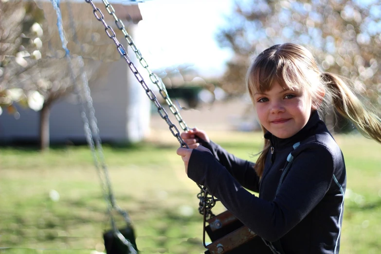 a little girl that is on a swing, a picture, taken with a canon eos 5 d, wearing a chain, widescreen, high res photo