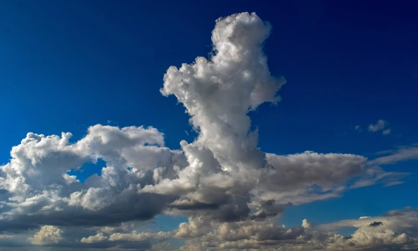 a large cloud in the middle of a blue sky, by Arnie Swekel, precisionism, cloud in the shape of a dragon, florida, towering high up over your view, hoog detail