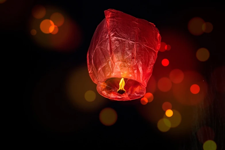 a red paper lantern with a lit candle in it, a picture, shutterstock, floating in the air, bokeh photo