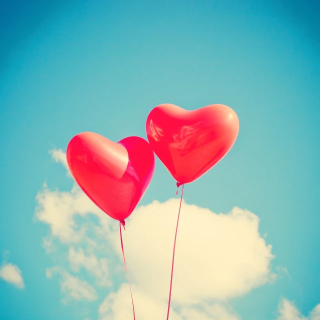 two red heart shaped balloons floating in the sky, romanticism, clear blue sky vintage style, watch photo