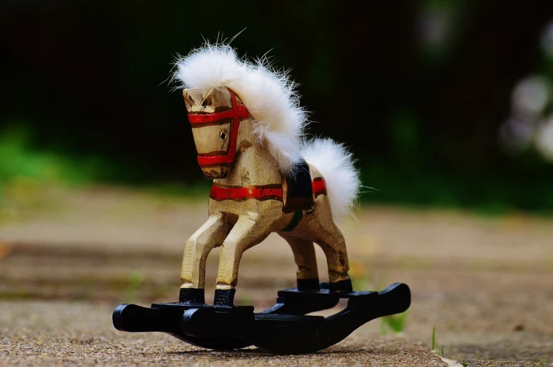 a toy horse sitting on top of a wooden rocking horse, by Tom Carapic, pixabay contest winner, folk art, with white fluffy fur, at full stride, tiny details, set photo