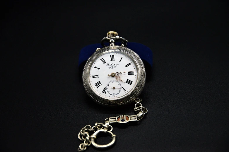 a close up of a pocket watch on a chain, a portrait, pixabay, bauhaus, silver and sapphire, highly detailed product photo, ukrainian, early 2 0 th century