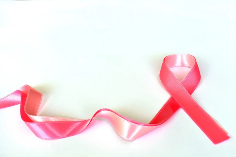 a pink ribbon laying on top of a white surface, a photo, gradient light red, biological photo, wide shot photo, document photo