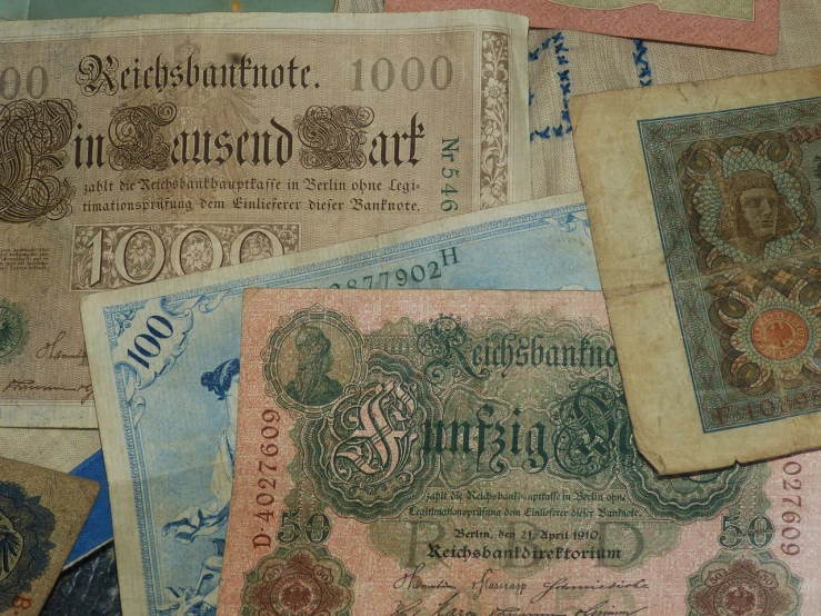 a pile of old paper money sitting on top of a table, by Anita Kunz, trending on pixabay, art nouveau, set in ww2 germany, victorian textiles, ebay photo, 1 9 0 0's photo