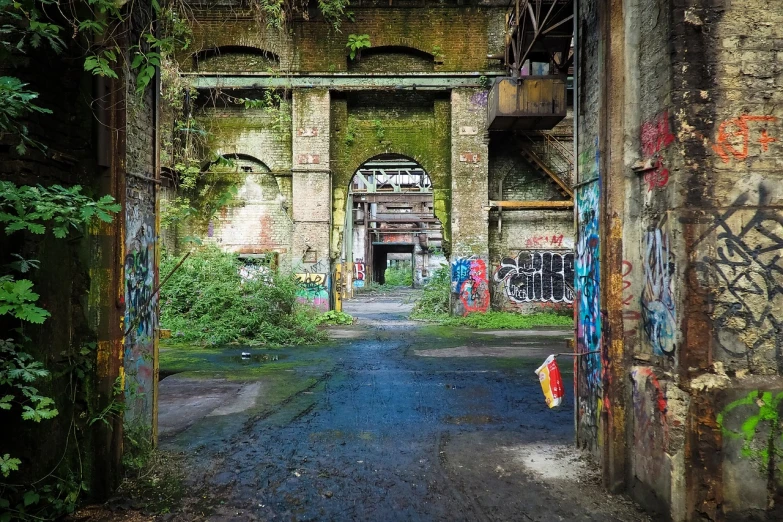 an old building with graffiti all over it, flickr, graffiti, archways made of lush greenery, abandoned steelworks, densley overgrown with moss, full of colours