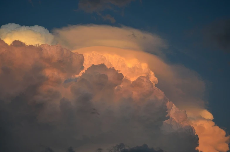 a plane flying through a cloud filled sky, a portrait, by Linda Sutton, flickr, romanticism, evening storm, giant cumulonimbus cloud, sunset glow around head, detailed zoom photo