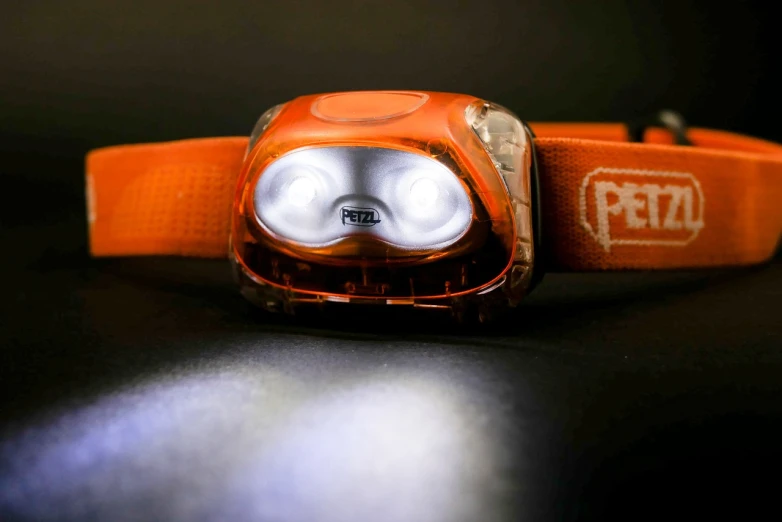 a close up of a headlame on a table, by Petr Brandl, flashlight, orange: 0.5, pepe, adventure