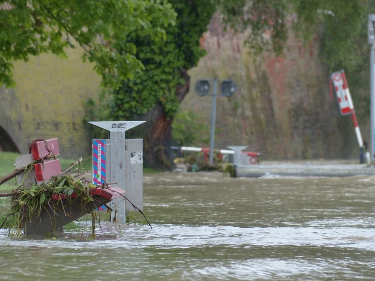 a red fire hydrant sitting in the middle of a flooded street, by Richard Carline, hurufiyya, 3 boat in river, sienna, floating power cables, urs fischer