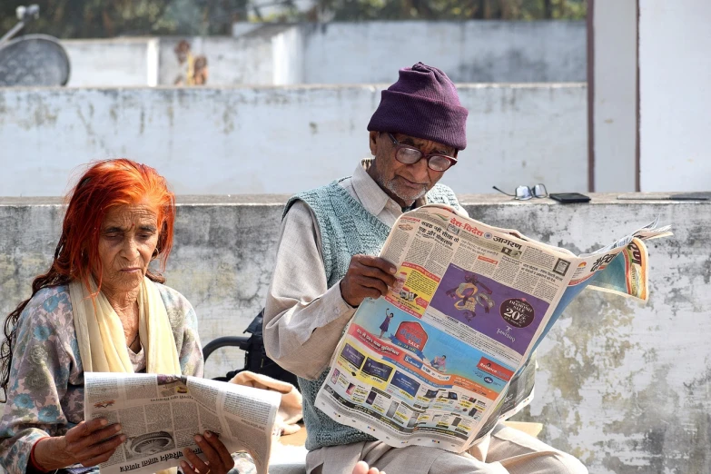 a man and a woman sitting on a bench reading a newspaper, a picture, by Narayan Shridhar Bendre, pexels, private press, an oldman, posing for camera, news broadcast, two frail