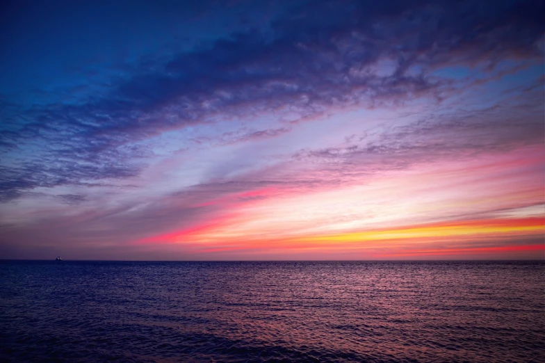 a large body of water with a sunset in the background, by Marc Bell, (((colorful clouds))), calm ocean, calm vivid colors, lined up horizontally