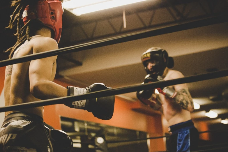 a couple of men standing next to each other in a boxing ring, by Matt Cavotta, pexels, helmet view, action with run and fight, tyler west, in a dojo
