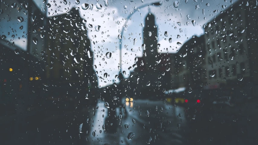 a view of a city through a rainy window, a picture, pexels, realism, driving rain, istock, low angle photo, tear drops