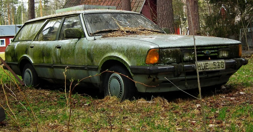 a car that is sitting in the grass, a photo, by Jacek Sempoliński, trending on pixabay, photorealism, lab covered in mold and moss, 80s nostalgia, swedish, the creature sells a used car