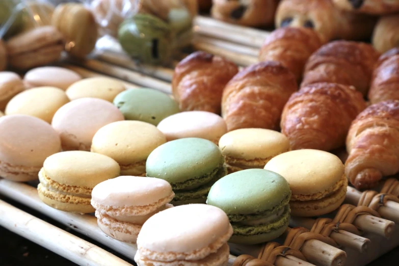 a display case filled with lots of different types of macarons, figuration libre, morning detail, pastel green, bread, focus on full - body