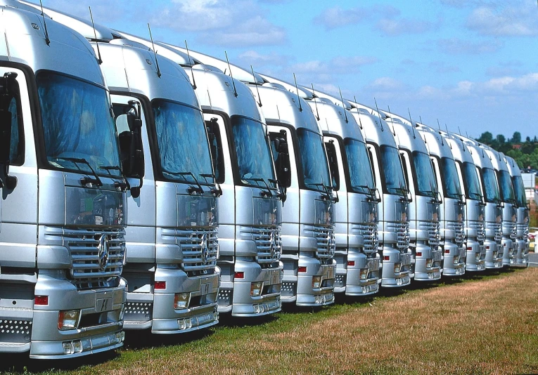 a row of silver trucks parked next to each other, a photo, photorealism, wikipedia, many smooth curves, full colour, anime”